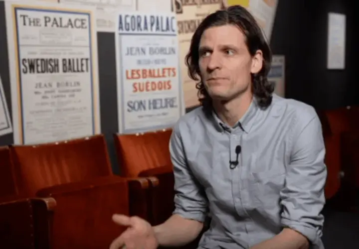 Erik Mattsson vid Dansmuseet, omgiven av affischer för Swedish Ballet och Les Ballets Suédois.