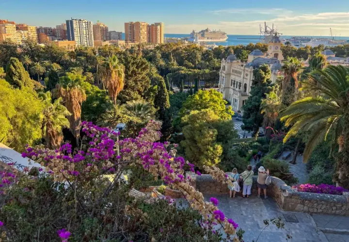 Malaga zwiedzanie: widok na park z palmami, budynki i port z rejsem. Spacer po urokliwych zakątkach miasta.