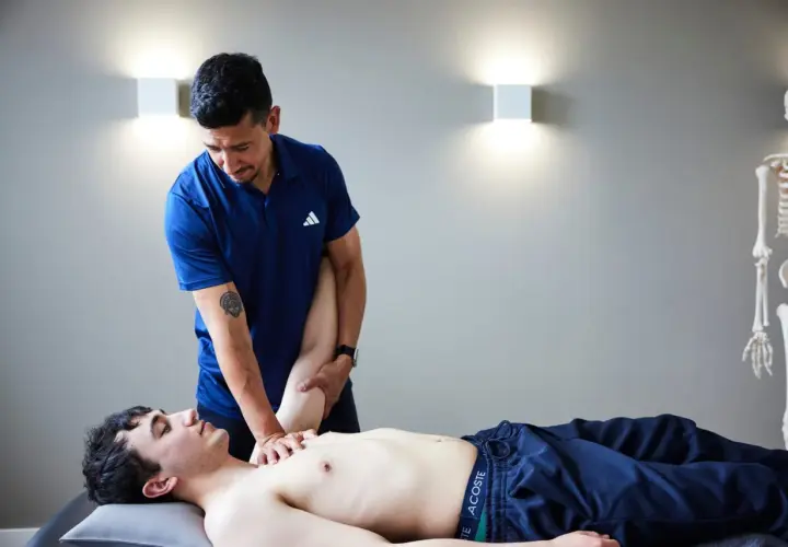 Ein Osteopath behandelt einen jungen Mann am Arm. Die Frage, wie oft Osteopathie hilft, wird hier visuell beantwortet.