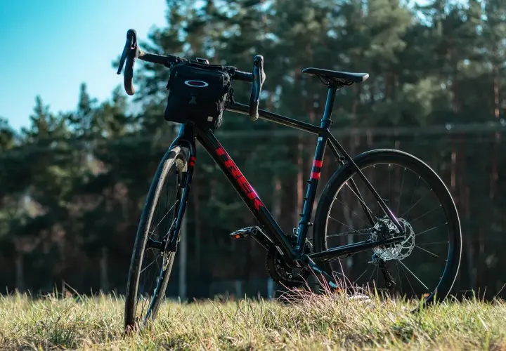 Czarny rower gravelowy z sakiewką na kierownicy, gotowy na wyprawę wzdłuż rzeki Loary.