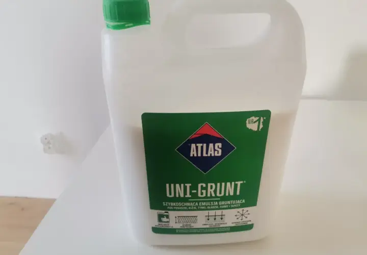 Biały kanister z zieloną nakrętką zawiera emulsję gruntującą Atlas Uni-Grunt. Idealny do przygotowania podłoża pod tynki i farby.