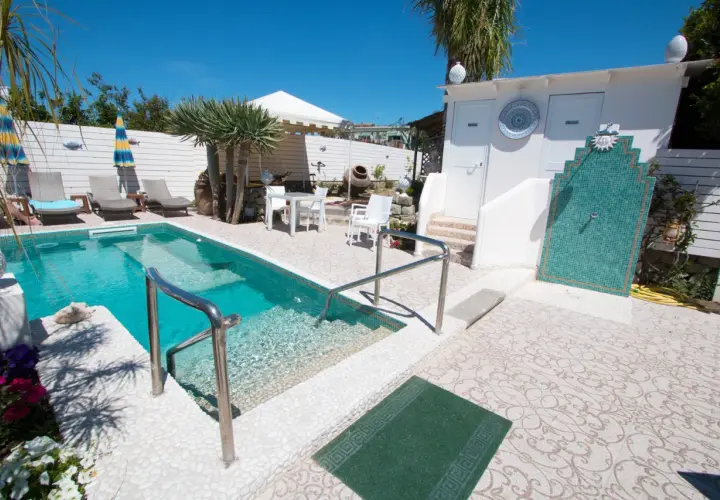 Piscina e doccia esterna in un'area relax, ideale per chi cerca "park hotel la villa ischia recensioni" per una vacanza indimenticabile.