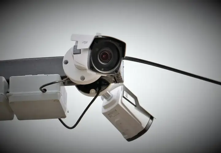 Dos cámaras de vigilancia blancas montadas en un poste. Interesado en cuanto consume una cámara de vigilancia.