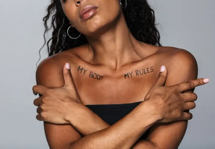 Kobieta z tatuażem na obojczyku: "MY BODY MY RULES". Wyrazisty napis, podkreślający siłę i autonomię.
