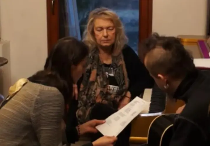 Katarzyna Gaertner z synem i młodą kobietą analizują nuty przy pianinie.
