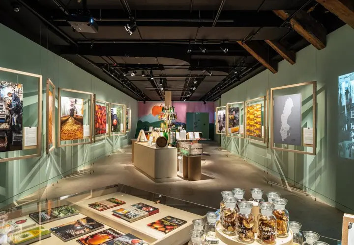 Utställning på Spritmuseum med bilder av produktion och ingredienser, samt flaskor med äppelmust.
