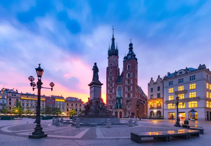 Krakowski Rynek Główny o wschodzie słońca. Bazylika Mariacka i pomnik Adama Mickiewicza, jedne z najpiękniejszych zabytków w Polsce.