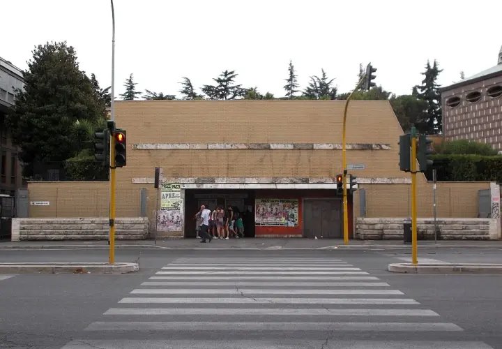Ingresso della metro Cornelia a Roma, con persone in attesa e semafori rossi.