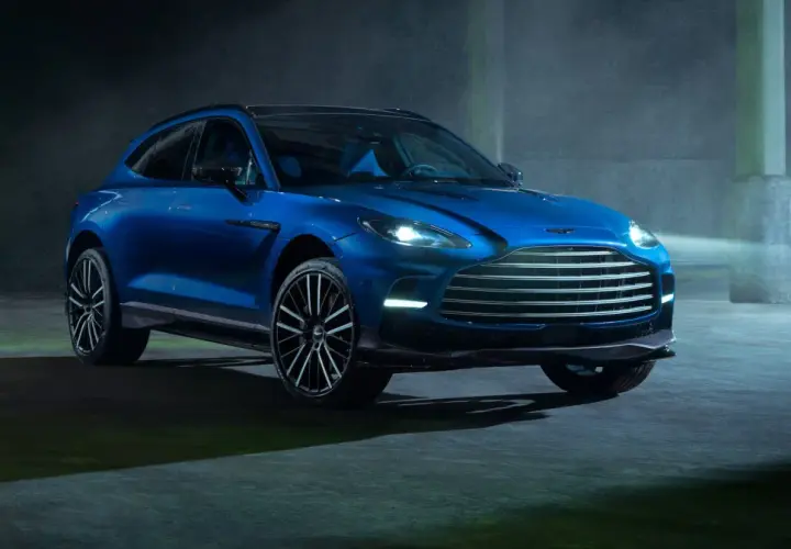 Niebieski Aston Martin DBX 707 lśni w półmroku, gotowy do podboju każdej drogi.