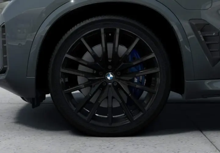 Nahaufnahme eines schwarzen BMW-Rads mit blauen Bremssätteln.