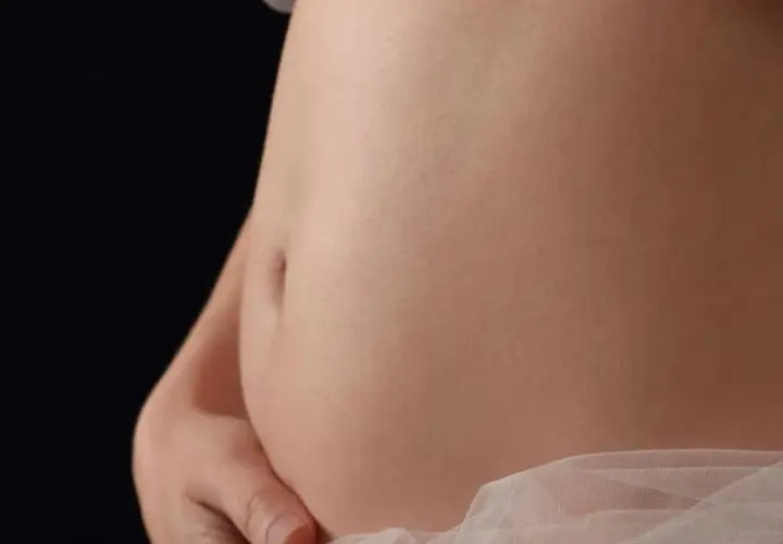 Primo piano di una pancia in gravidanza, che mostra la sua crescita settimana per settimana.