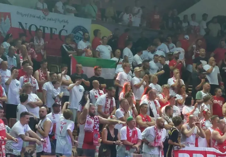 Tłum kibiców w biało-czerwonych barwach, z flagami i szalikami. Widać transparent z napisem "NOTEĆ". Atmosfera przypomina mecz, gdzie Polska rywalizuje z Izraelem.