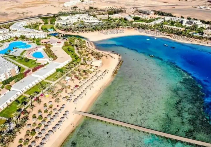 Widok z lotu ptaka na Royal Brayka Beach Resort z basenami, palmami, piaszczystą plażą i turkusowym morzem.