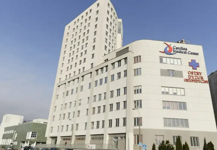 Nowoczesny budynek Carolina Medical Center w Warszawie z napisem "Ostry Dyżur Ortopedyczny".