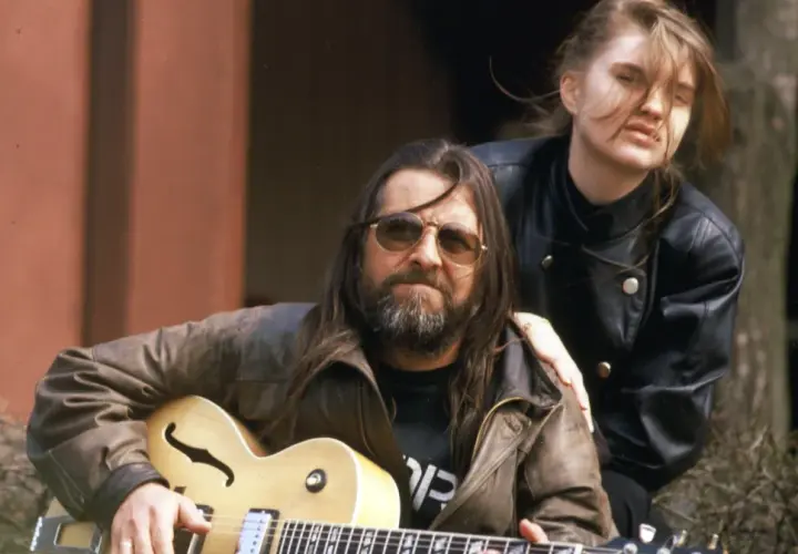 Grażyna Dramowicz biografia: muzyk z gitarą i młoda kobieta w skórzanej kurtce.