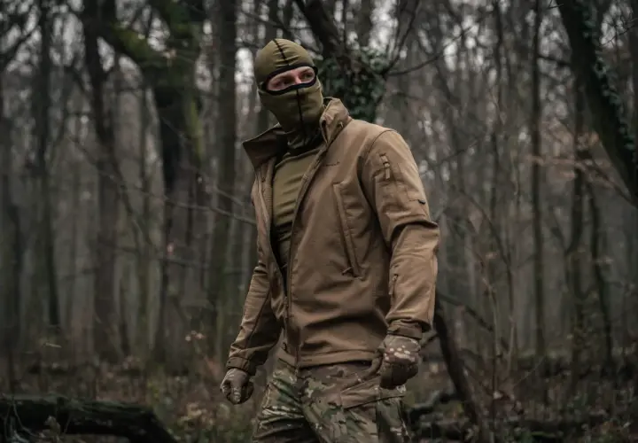 Mężczyzna w lesie, ubrany w kurtkę i maskę, nosi bieliznę termoaktywną Helikon.