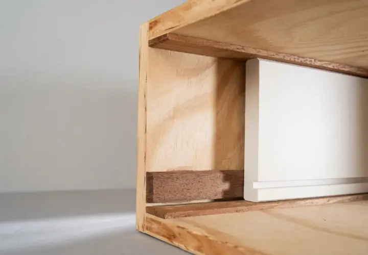 Detailaufnahme einer weißen Schubladenfront, die in einen Holzrahmen gleitet. Perfekt, wenn Sie eine Schublade selber bauen möchten.
