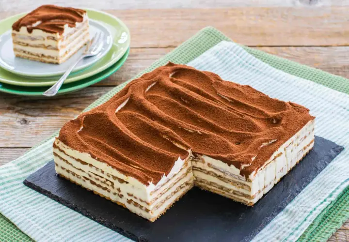 Un invitante tiramisù con oro Saiwa, stratificato e cosparso di cacao, pronto per essere gustato.