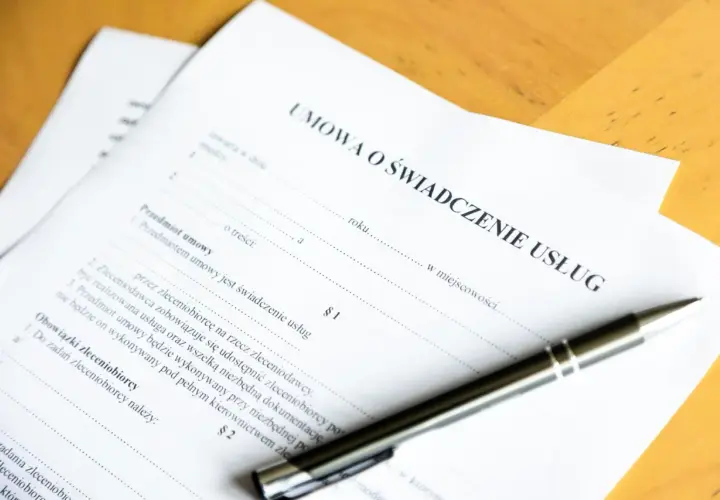 Umowa o świadczenie usług. Czy świadczenie integracyjne wlicza się do stażu pracy? Długopis leży na dokumencie.