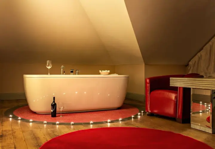 Romantyczny weekend w Kazimierzu Dolnym dla dwojga: wanna, świece, wino i czerwony fotel tworzą idealną atmosferę.