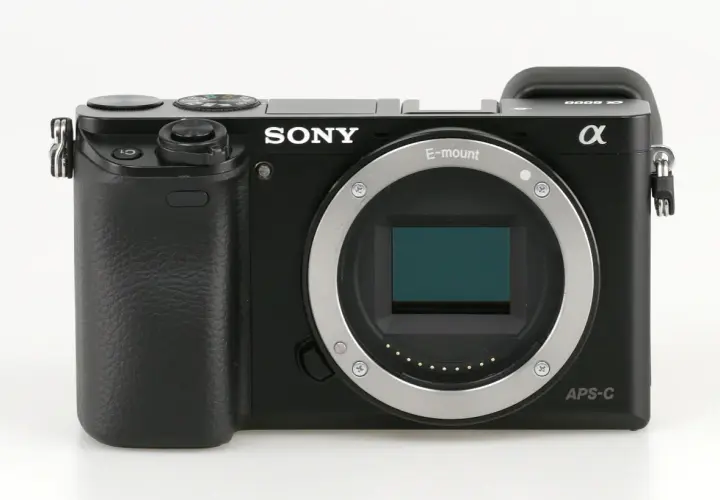 Czarny aparat Sony a6000, gotowy do testów. Widoczny obiektyw E-mount i sensor APS-C.