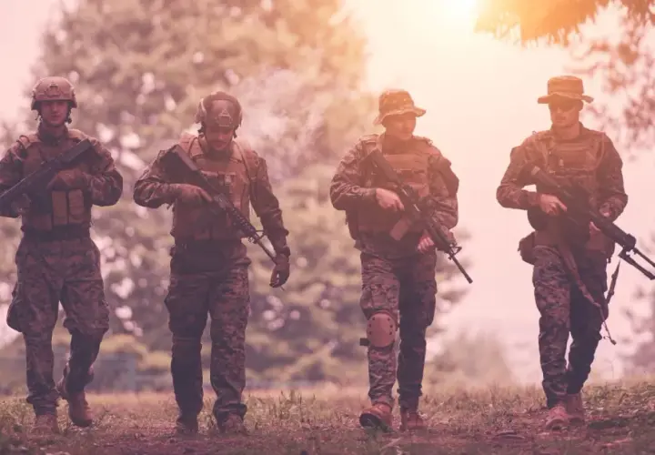 Czterech żołnierzy w kamuflażu, z karabinami, idzie przez las. Czy to przygotowanie do "Escape from Tarkov wymagania"?