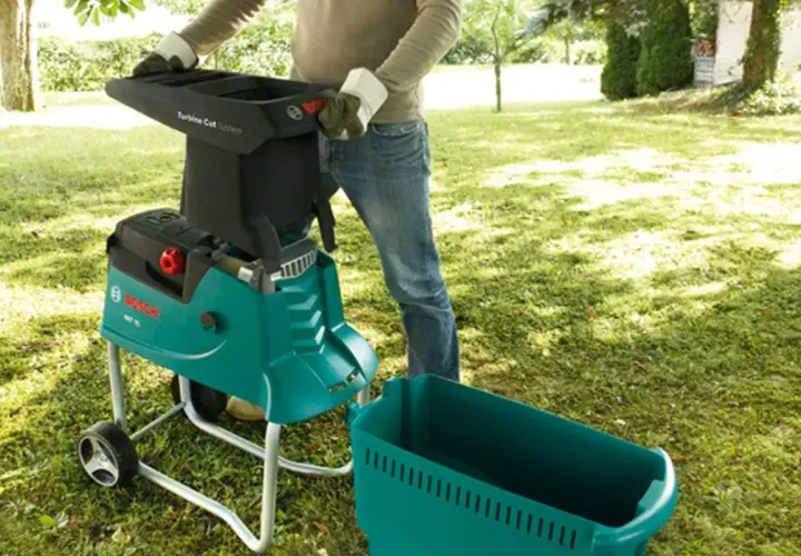 Gartenarbeit leicht gemacht: Ein Mann bedient einen Bosch Häcksler, den meister shredder, im Garten.
