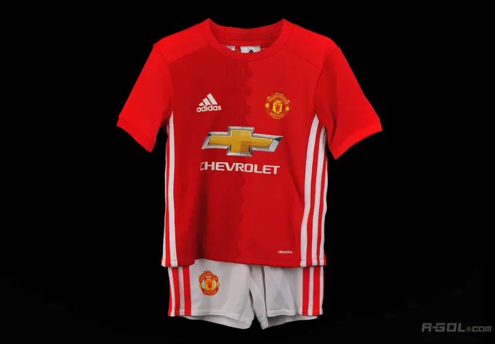 Dziecięcy komplet piłkarski Manchester United: czerwona koszulka i białe spodenki.