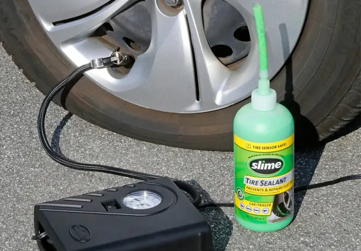 Un kit antipinchazos Slime, con su sellador verde y compresor negro, listo para reparar una rueda.