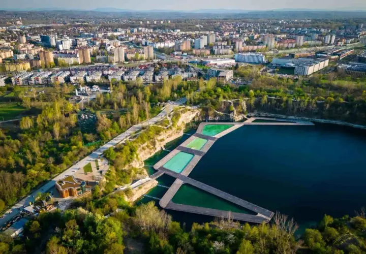 Widok na Zakrzówek Kraków kąpielisko z drewnianymi pomostami i basenami w otoczeniu zieleni i zabudowy miejskiej.