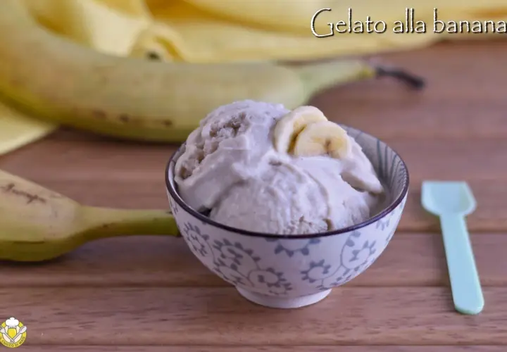 Una ciotola di cremoso gelato alla banana, guarnito con fettine di banana, accanto a banane fresche e un cucchiaino.