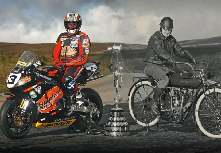 Conor Cummins junto a su moto de carreras y un trofeo, junto a un piloto histórico en una Indian.