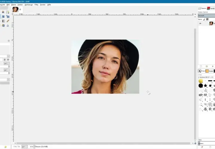 Kobieta w kapeluszu na ekranie programu GIMP, przygotowana do kadrowania.