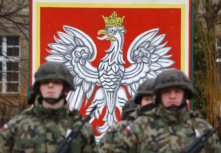 Żołnierze w mundurach stoją przed godłem Polski. Dowódca kompanii, stopień wojskowy, jest gotowy do akcji.