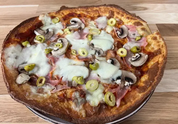 Chrupiący spód do pizzy z pieczarkami, szynką i oliwkami, polany ciągnącym się serem.