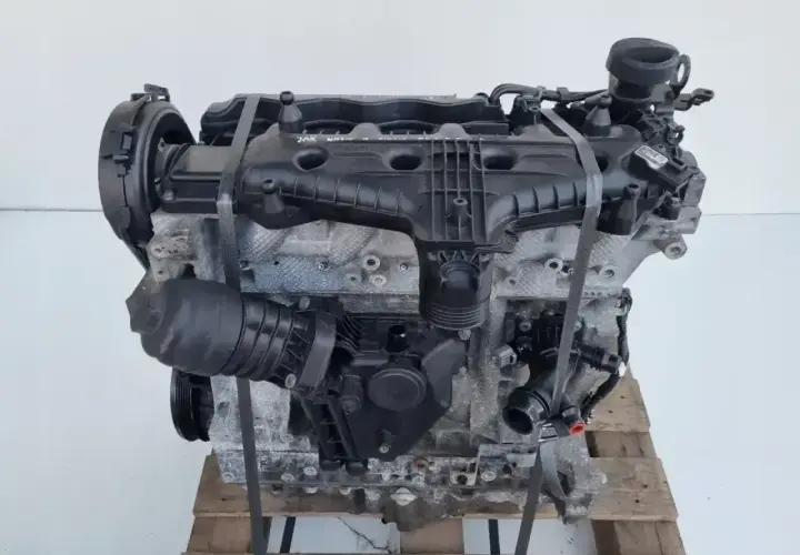 Silnik Volvo T6, gotowy do montażu. Potężna jednostka napędowa z widocznymi elementami osprzętu, umieszczona na drewnianej palecie.