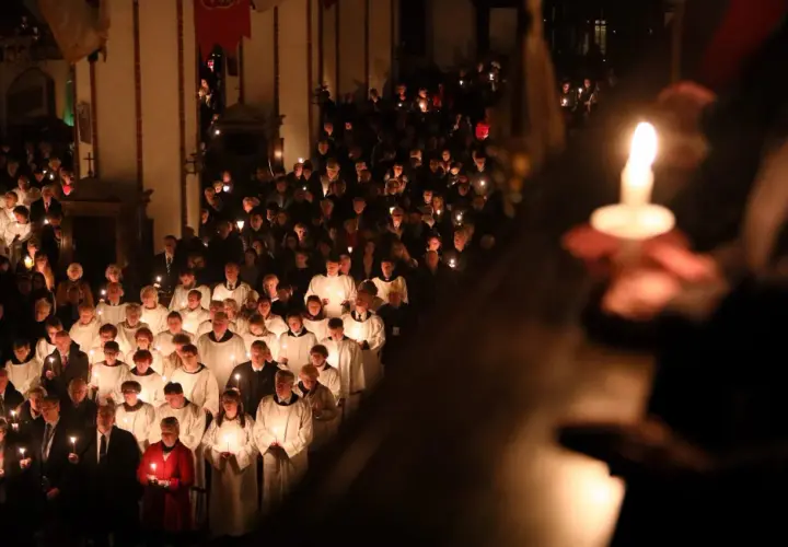 Uczestnicy niosący świece w kościele podczas Wigilii Paschalnej. Długość nabożeństwa jest różna, ale atmosfera jest podniosła.