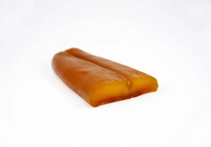 Zwei goldbraune, längliche Stücke Bottarga di Muggine liegen nebeneinander auf weißem Grund.