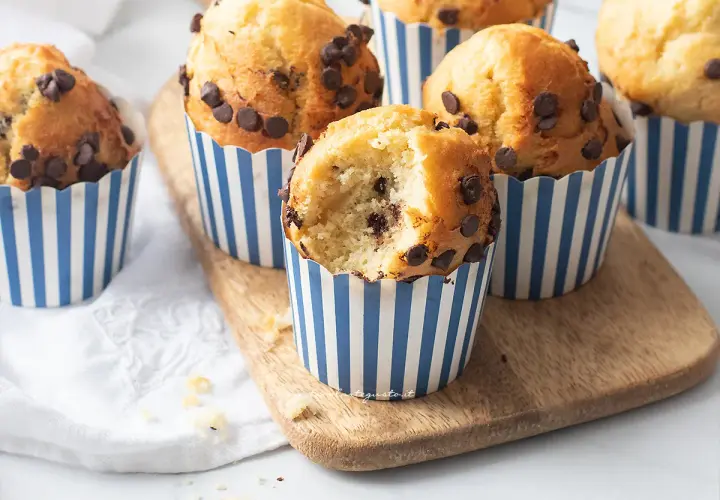 Muffin in friggitrice ad aria con gocce di cioccolato, uno è stato morso rivelando un interno soffice e goloso.