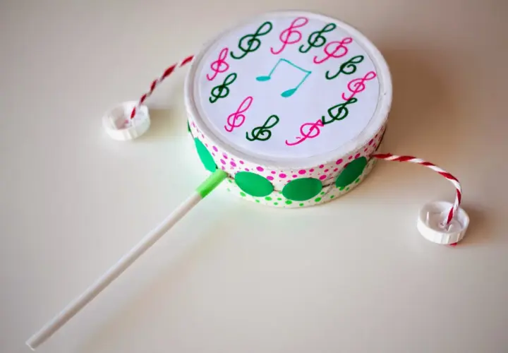 Tambor casero decorado con notas musicales, hecho con materiales reciclados. Un ejemplo de divertidos instrumentos musicales caseros.