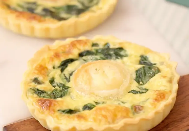 Une délicieuse quiche épinard chèvre, dorée et appétissante, avec une touche de fromage de chèvre au centre.