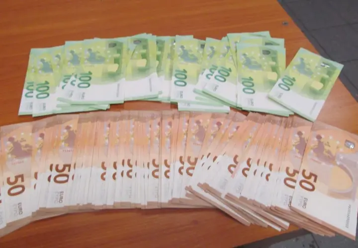Duże stosy banknotów 100 i 50 euro leżą na drewnianym stole. Zastanawiasz się, ile gotówki można przewozić samolotem?