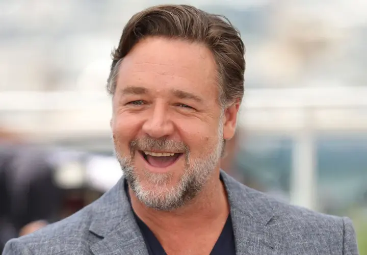 Uśmiechnięty Russell Crowe w szarym garniturze. Zastanawiasz się, ile lat ma Russell Crowe?
