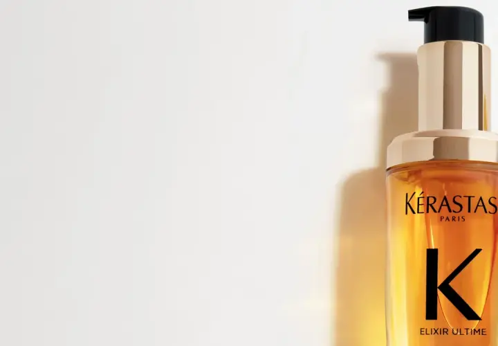 Lyxig flaska med Kérastase Elixir Ultime olja i håret. Ger glans och näring.