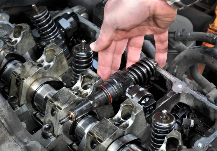 Mano manipulando un inyector de gasolina, posiblemente indicando un fallo de inyectores gasolina.