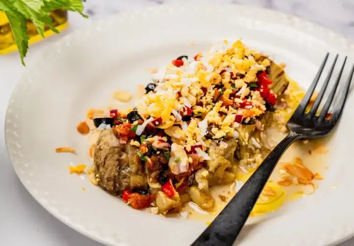 Deliciosa ensalada de berenjenas asadas con huevo picado, aceitunas negras, pimientos y almendras.