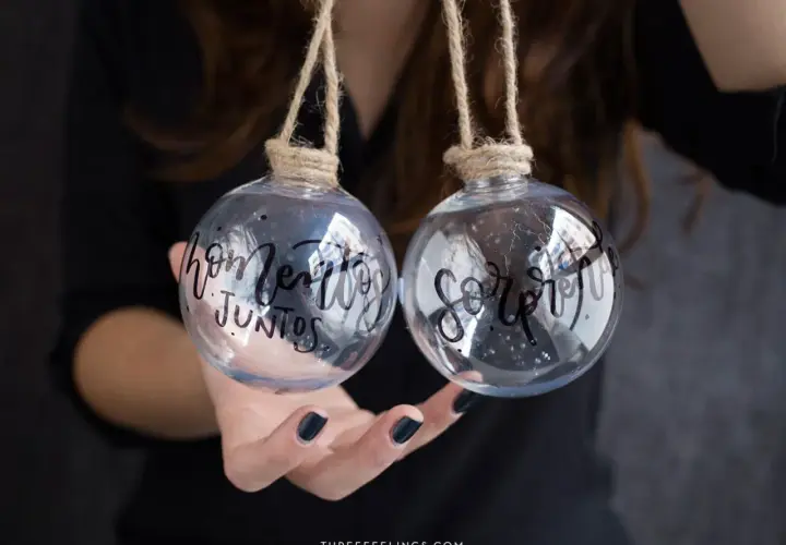 Dos bolas de navidad personalizadas con nombre, una dice "hogar" y la otra "juntos".