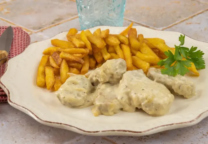 Filet mignon maroilles, tendre viande enrobée d'une sauce crémeuse, accompagnée de frites dorées et d'une touche de persil frais. Un délice !