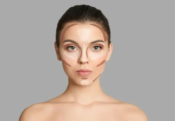 Modelka pokazuje, jak nakładać bronzer i rozświetlacz, tworząc efekt konturowania twarzy.