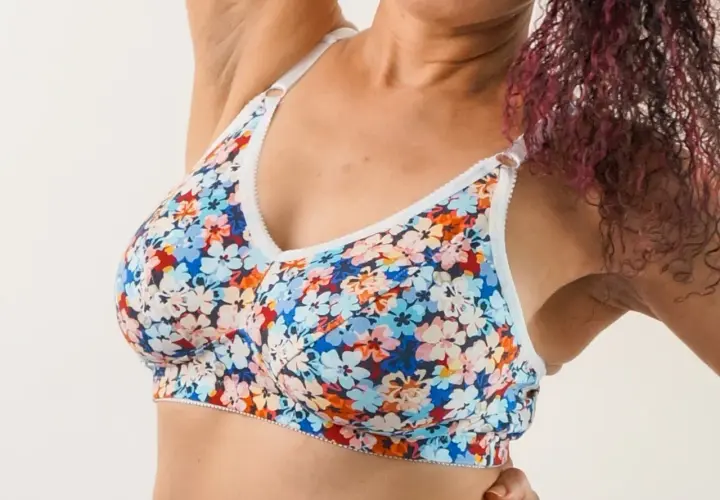 A woman wears a colorful floral bra. This bra pattern is free to download and create your own!